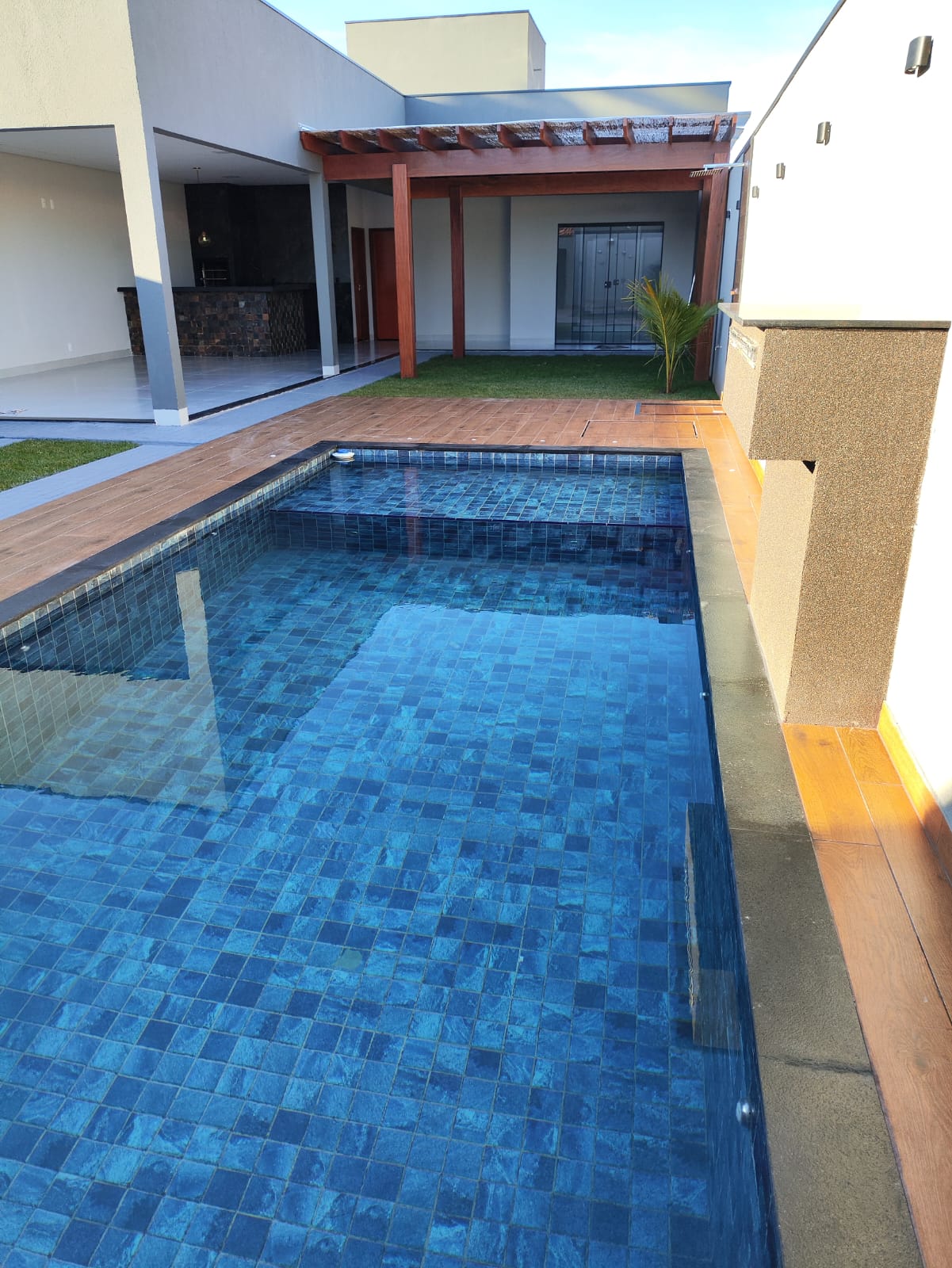 Piscina revestida em pastilhas e deck