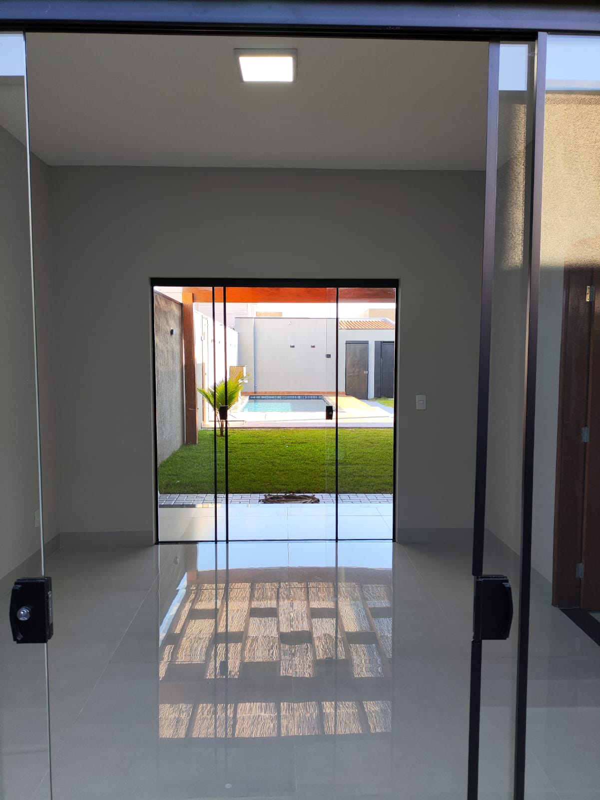 Sala com porcelanato e porta de vidro